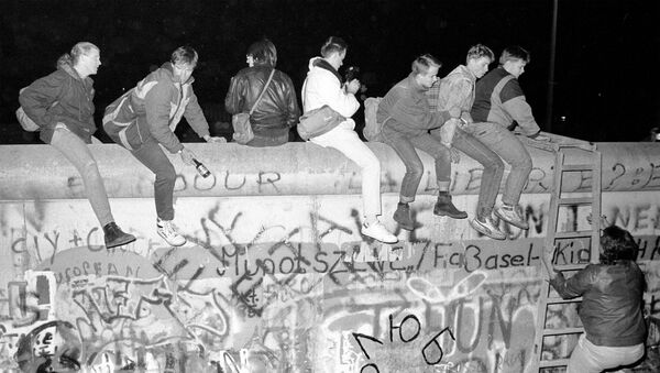 На фото сверху граждане Западной Германии сидят на вершине Берлинской стены на Zimmer Strasse 9 ноября 1989 года, и внизу -  то же место 30 октября 2019 года, Германия - Sputnik Южная Осетия