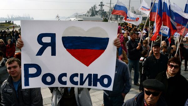 Житель Владивостока держит плакат с надписью Я люблю Россию во время празднования Дня народного единства - Sputnik Южная Осетия