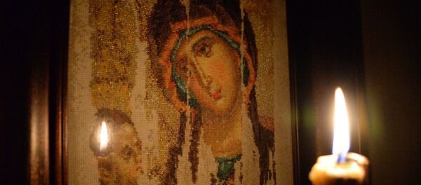 Горящая свеча на фоне вышитого изображения Казанской иконы Божьей матери Горящая свеча на фоне вышитого изображения Казанской иконы Божьей матери - Sputnik Южная Осетия