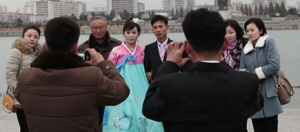 Молодожены во время свадебной фотосессии со своими родственниками в Пхеньяне Молодожены во время свадебной фотосессии со своими родственниками в Пхеньяне - Sputnik Южная Осетия