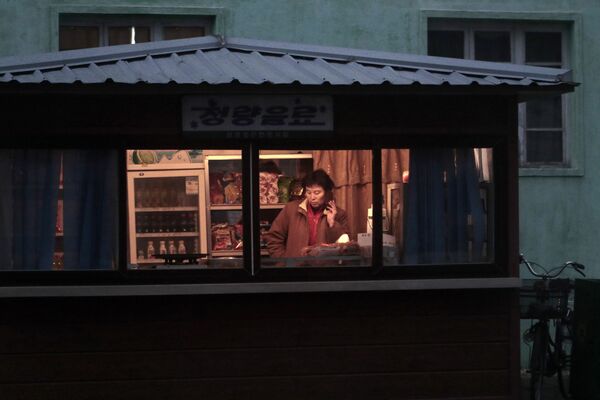 Продавец в киоске с закусками и напитками в Пхеньяне - Sputnik Южная Осетия
