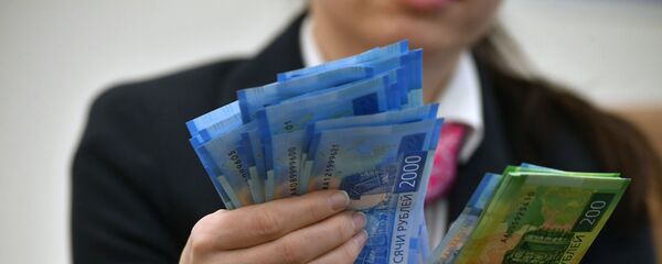 Сотрудница банка пересчитывает денежные купюры Сотрудница банка пересчитывает денежные купюры - Sputnik Южная Осетия