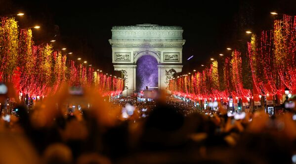 Зрители во время праздничного светового шоу перед Триумфальной аркой в Париже - Sputnik Южная Осетия
