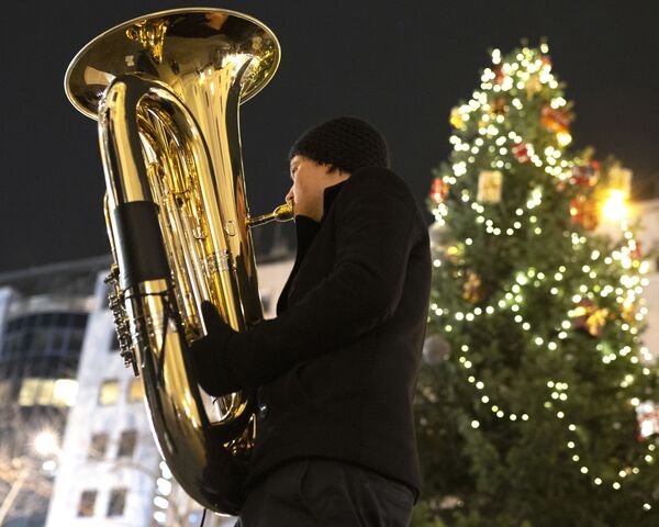 Музыкант духового оркестра Rudersdorf Music Society играет на трубе на рождественском базаре в Вене - Sputnik Южная Осетия