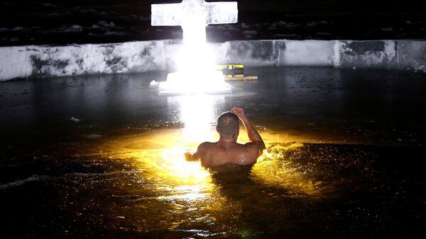 Минчанин купается в проруби во время празднования Крещения Господнего в Белоруссии - Sputnik Южная Осетия