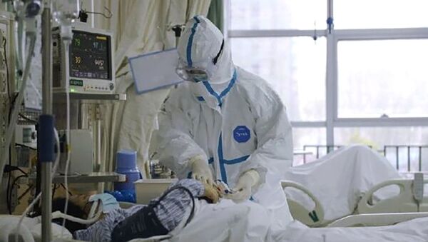 Врач в защитном костюме у постели больного коронавирусом 2019-nCoV в Центральном госпитале города Ухань, Китай (23 января 2020). - Sputnik Южная Осетия